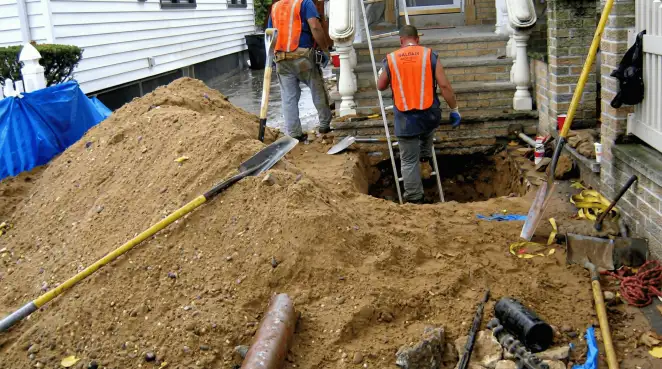 Contractors performing foundation protection and exterior drainage excavation near residential home steps in Columbus, OH